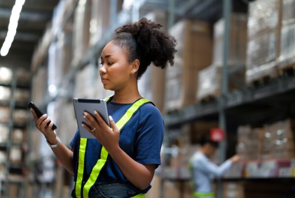 Young woman in a warehouse using tablets and scanners to manage inventory